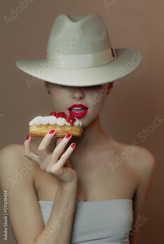 Portrait of beautiful young happy girl eating cake, close up. Chocolate background. Smiling girl playing with dessert.