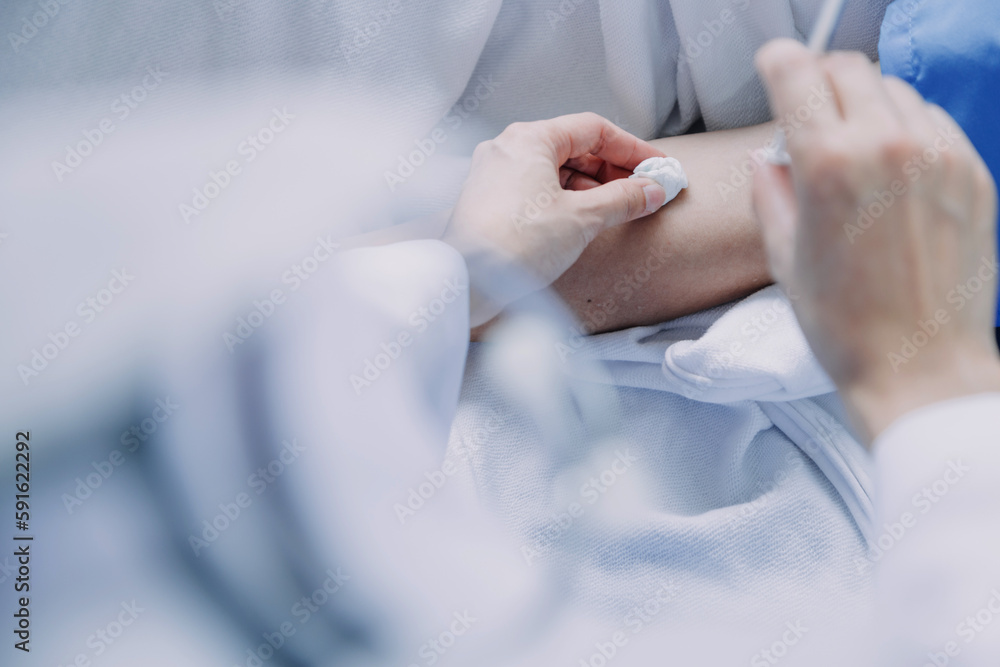 Side view of diverse doctors examining Asian female patient in bed in ward at hospital. Side view of diverse doctors examining Asian female patient in bed in ward at hospital.