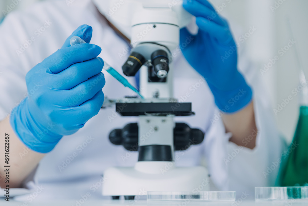 biochemical research scientist team working with microscope for coronavirus vaccine development in pharmaceutical research labolatory, selective focus biochemical research scientist team working with microscope for coronavirus vaccine development in pharmaceutical research labolatory, selective focus