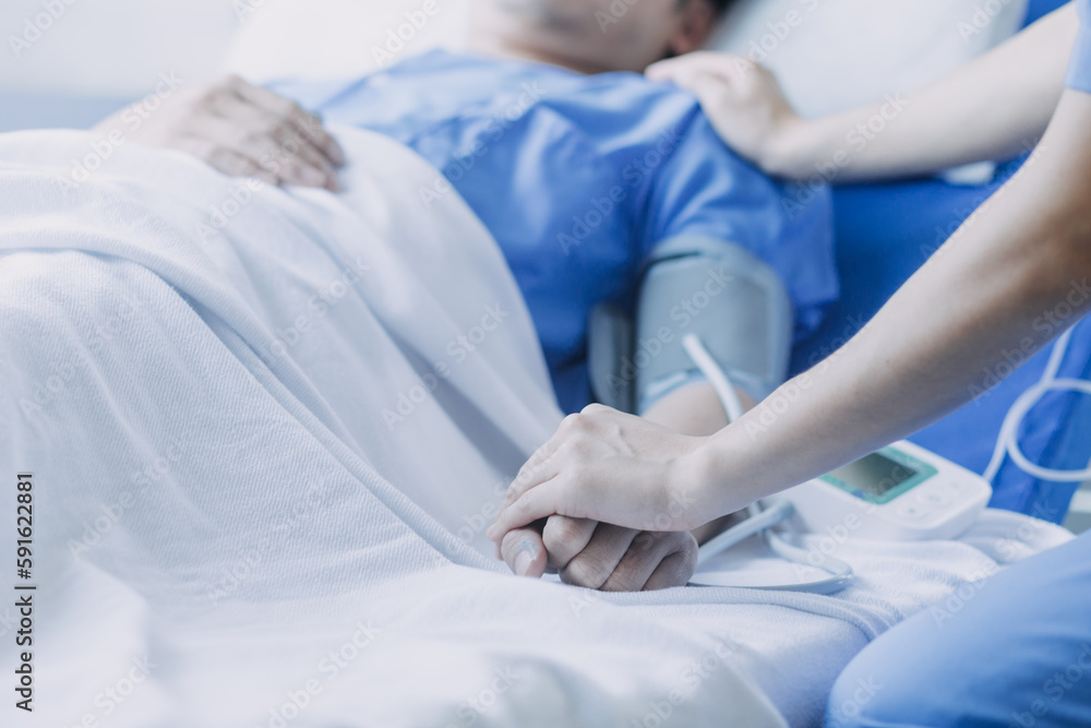 Side view of diverse doctors examining Asian female patient in bed in ward at hospital. Side view of diverse doctors examining Asian female patient in bed in ward at hospital.