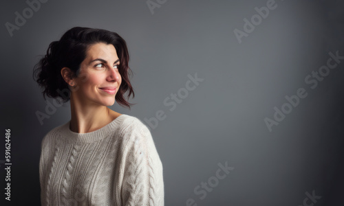 Portrait of a beautiful woman in a white sweater on a gray background