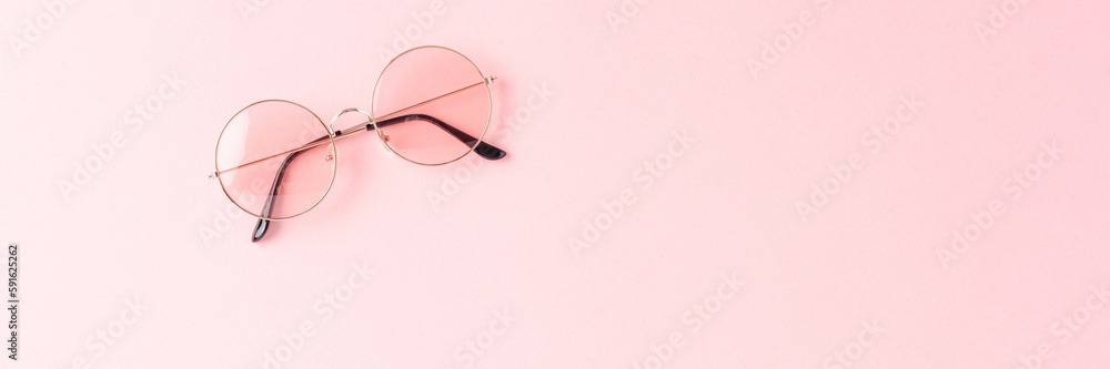 Round sunglasses on pink background. Flat lay Round sunglasses on pink background. Flat lay