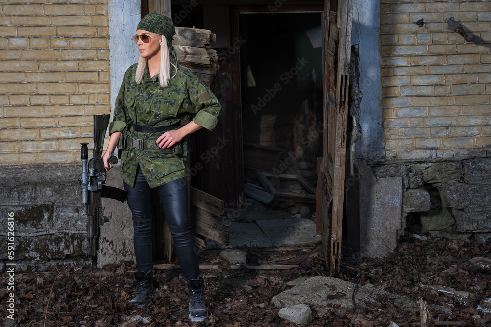 A sniper girl in military uniform with a rifle with an optical sight in a war in a destroyed city. A sniper girl in military uniform with a rifle with an optical sight in a war in a destroyed city.