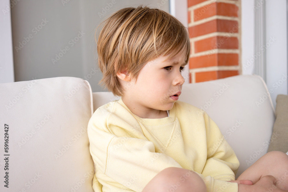 Sad child boy portrait sitting in the terrace at home. Sad child boy portrait sitting in the terrace at home.