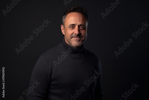 Portrait of a middle-aged man in a black sweater on a black background.