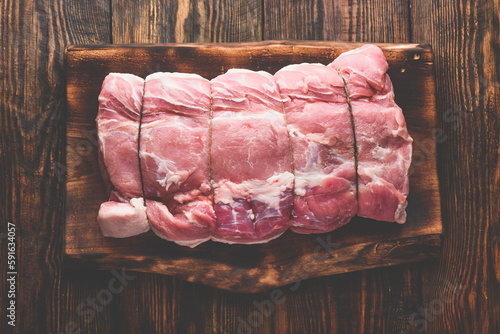 Pork loin joint on rustic cutting board
