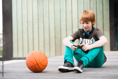 Boy with MP3 Player Outdoors, Mannheim, Baden-Wurttemberg, Germany photo