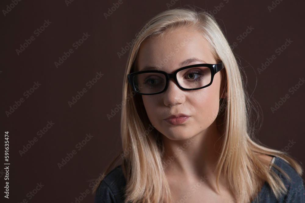 Close-up Portrait of Blond, Teenage Girl, wearing Eyeglasses and Looking to the Side, Studio Shot on Black Background Close-up Portrait of Blond, Teenage Girl, wearing Eyeglasses and Looking to the Side, Studio Shot on Black Background