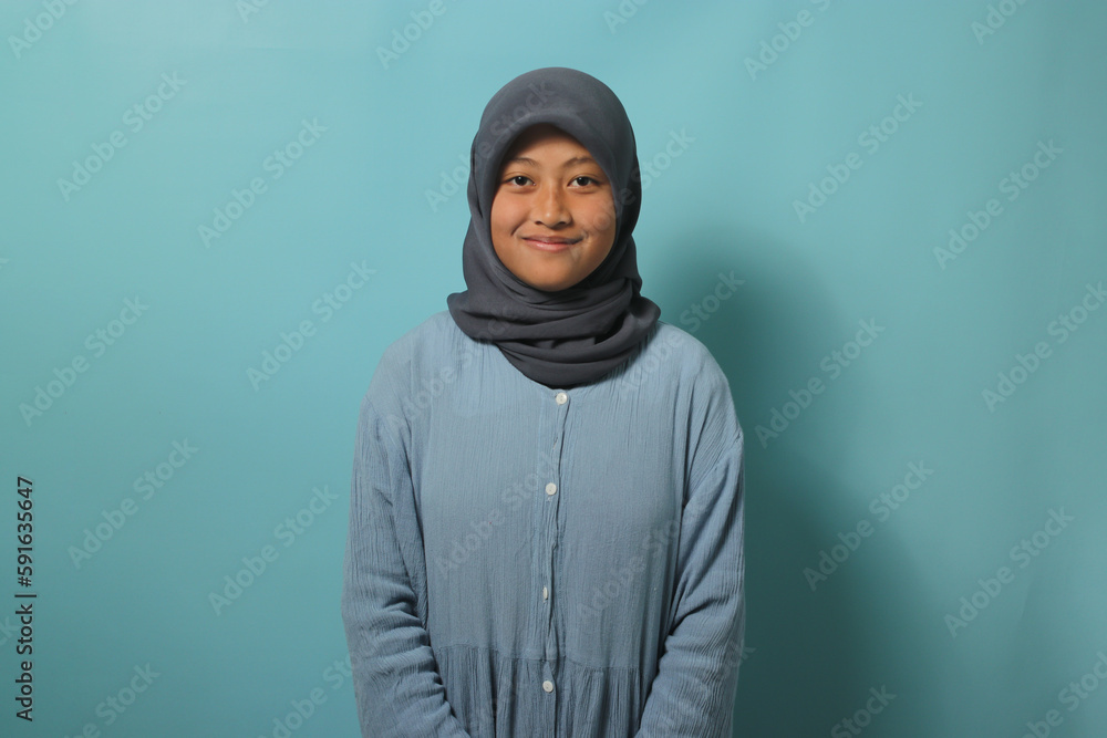 Young Asian girl in hijab smiling at camera Young Asian girl in hijab smiling at camera