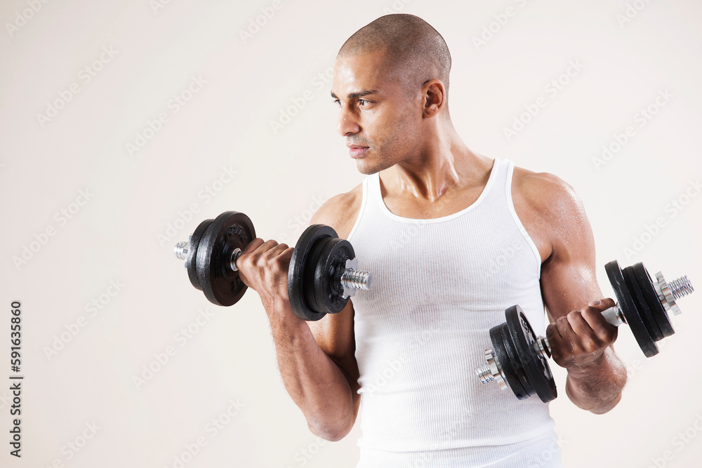 Man Wearing Work Out Clothes and Lifting Weights in Studio with White Background Man Wearing Work Out Clothes and Lifting Weights in Studio with White Background
