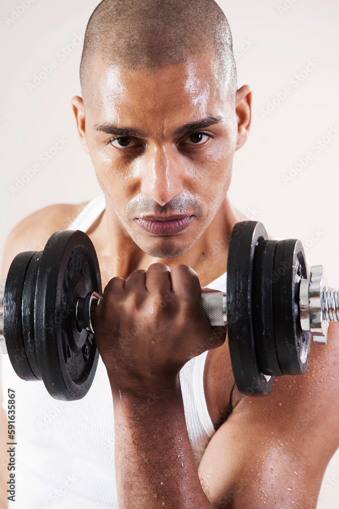 Man Wearing Work Out Clothes and Lifting Weights in Studio with White Background Man Wearing Work Out Clothes and Lifting Weights in Studio with White Background