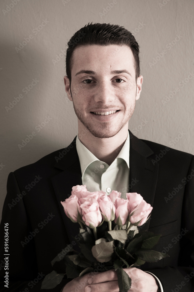 Portrait of Young Man holding Bouquet of Pink Roses, Looking at Camera, Studio Shot Portrait of Young Man holding Bouquet of Pink Roses, Looking at Camera, Studio Shot