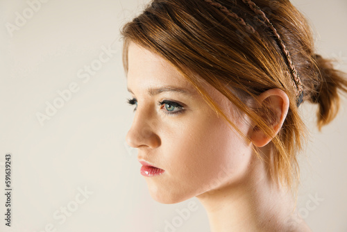 Close-up, Side View Portrait of Teenage Girl in Upsweep Hairstyle and wearing Make-up, Studio Shot on White Background photo