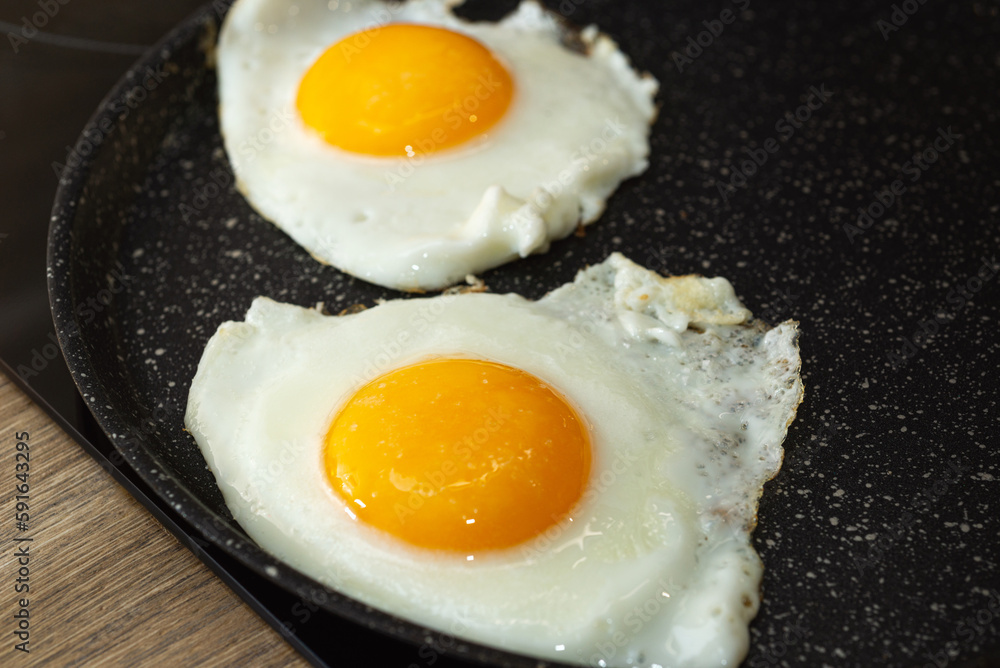 Frying eggs in a frying pan on electric stove Frying eggs in a frying pan on electric stove