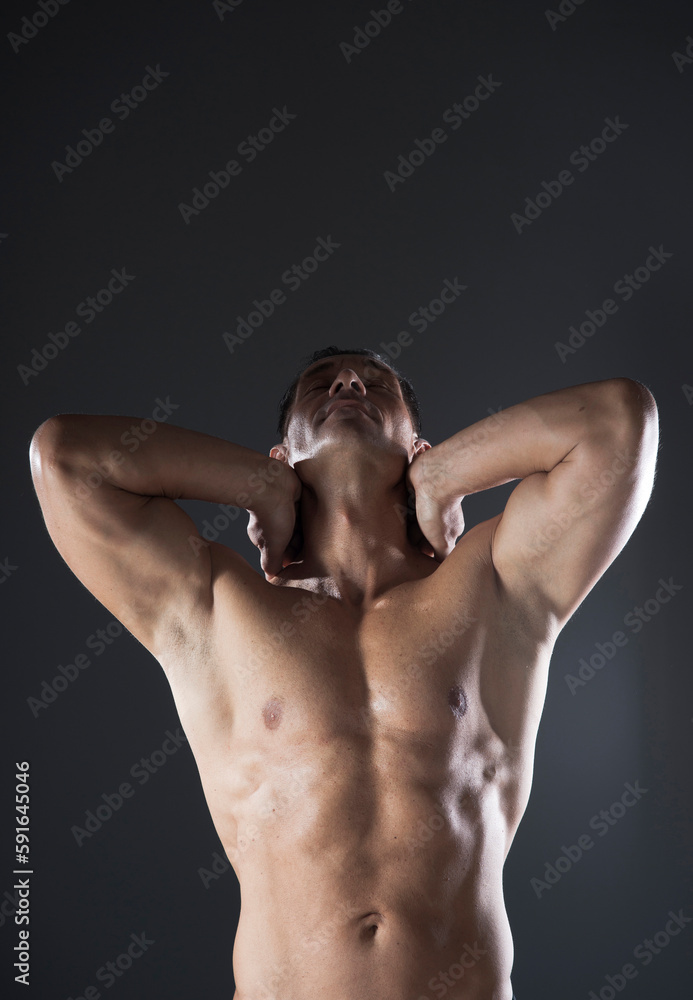 Muscular Man with Hands behind Head, Studio Shot Muscular Man with Hands behind Head, Studio Shot