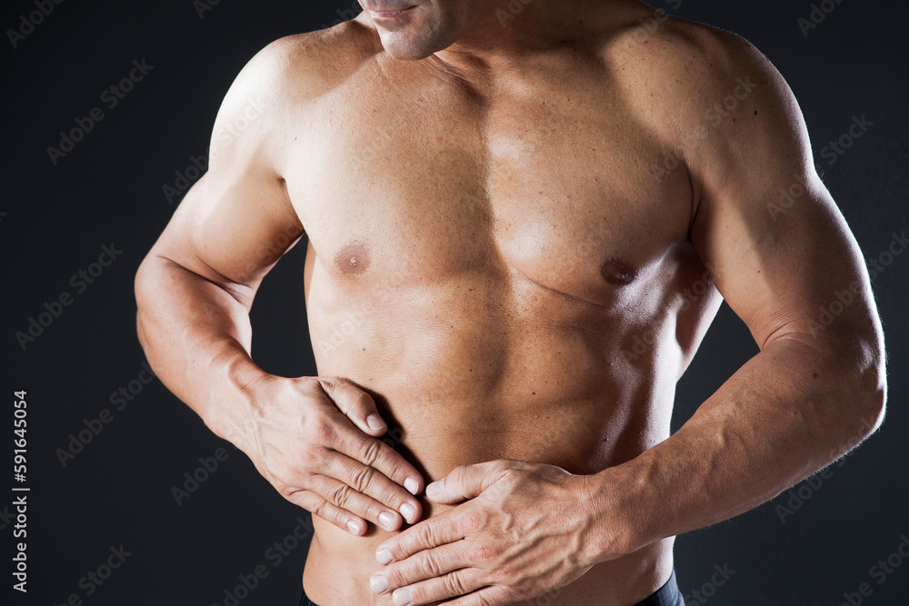 Close-up of Muscular Man with Hands on Stomach, Studio Shot Close-up of Muscular Man with Hands on Stomach, Studio Shot