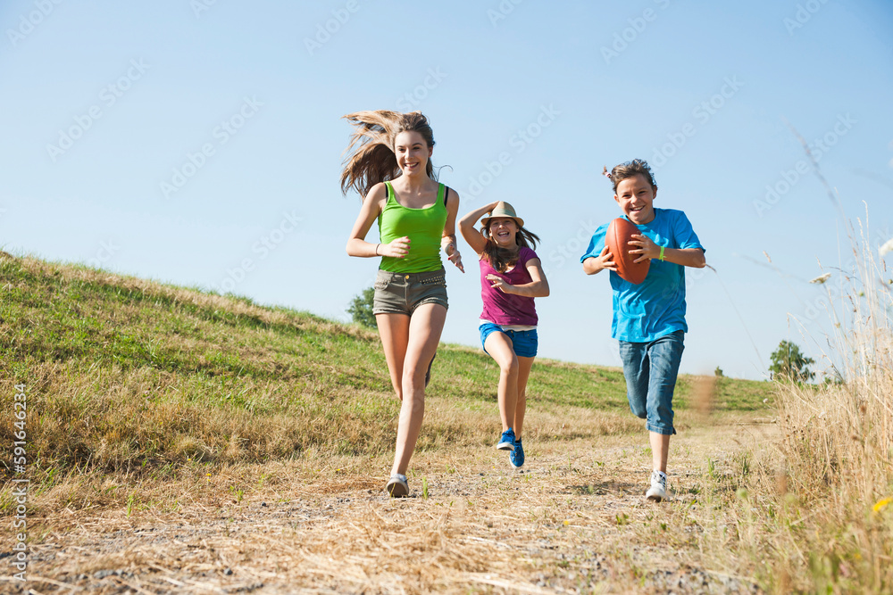 Girls running along pathway in field, Germany Girls running along pathway in field, Germany