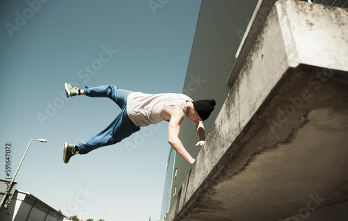 Low angle view of teenaged boy doing handstand on balcony, freerunning, Germany photo