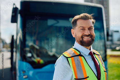 Fotografie Happy bus driver in front of vehicle looking at camera.