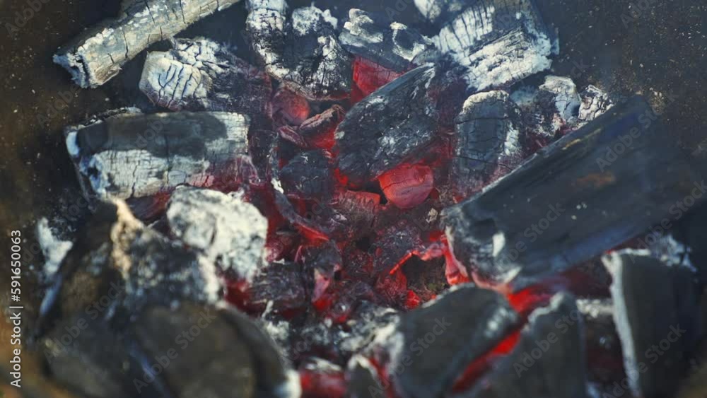 Hot ashy charcoals burning in red hot temperature up close in slow motion Hot ashy charcoals burning in red hot temperature up close in slow motion