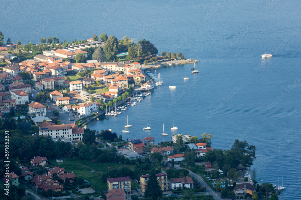 The peaceful harbor of Lake Como is a perfect setting with white boats and traditional houses