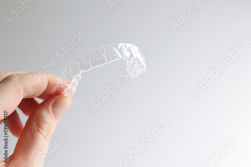 Aligners for straightening teeth on a light background in a woman's hand