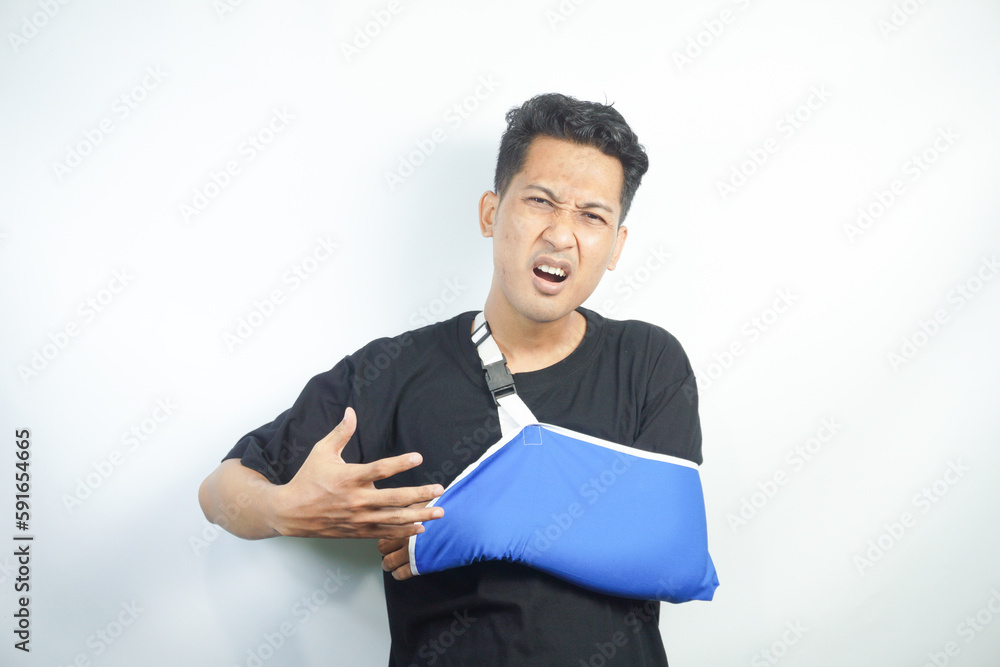 Portrait of young Caucasian man with splint on arm after accident or trauma. Male patient with bandage or sling on hand or shoulder struggle with injury have rehabilitation. Recovery and rehab. Portrait of young Caucasian man with splint on arm after accident or trauma. Male patient with bandage or sling on hand or shoulder struggle with injury have rehabilitation. Recovery and rehab.