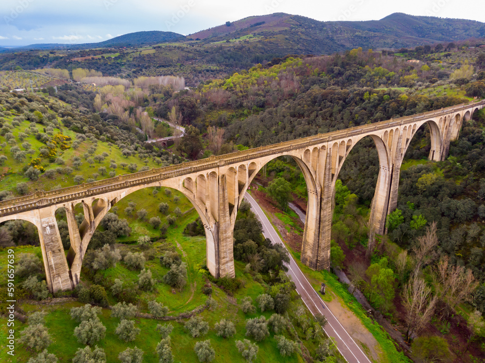Scenic drone view of green spring hilly landscape with Guadalupe viaduct built in early 20th century, planned as railway bridge, Spain..
