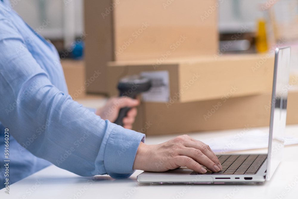 Quality assurance in online sales: Checking product barcodes before delivery to customers for freelance and SME business owners, close up laptop and hand with barcode scanner with boxes