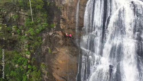 Aerial view of couple abseiling in a huge waterfall, Minas Gerais, Brazil