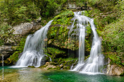 Fototapeta Naklejka Na Ścianę i Meble -  Side view of fairytale Virje waterfall in Slovenia - Pluzna. Dreamy and beautiful natural double waterfall shot on long exposure.