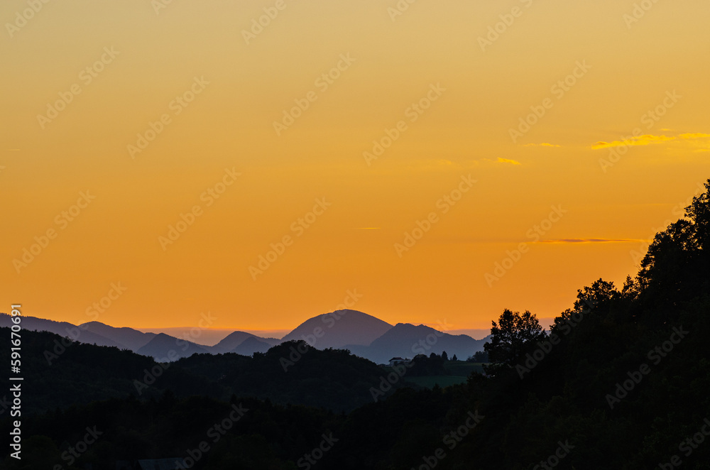 A beautiful orange sunset with a silhouette of the mountains.