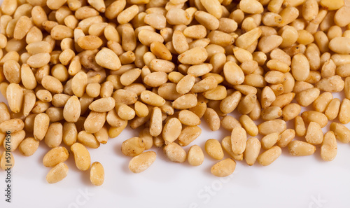 Closeup of shelled pine nuts on white background. Concept of healthy and nutritious food