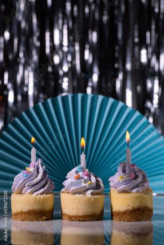 Mini cheesecakes with purple icing and birthday candles