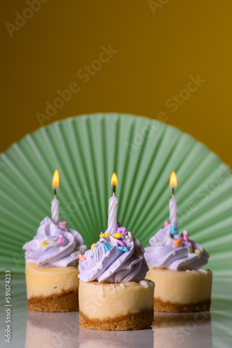 Mini cheesecakes with icing, sprinkles and birthday candles