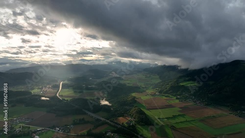 ALPS, AUSTRIA - OCTOBER, 2022: Aerial view of austrian mountain village Lendorf and beautiful valley. Green meadows and autumn forest with yellow leaves around. photo