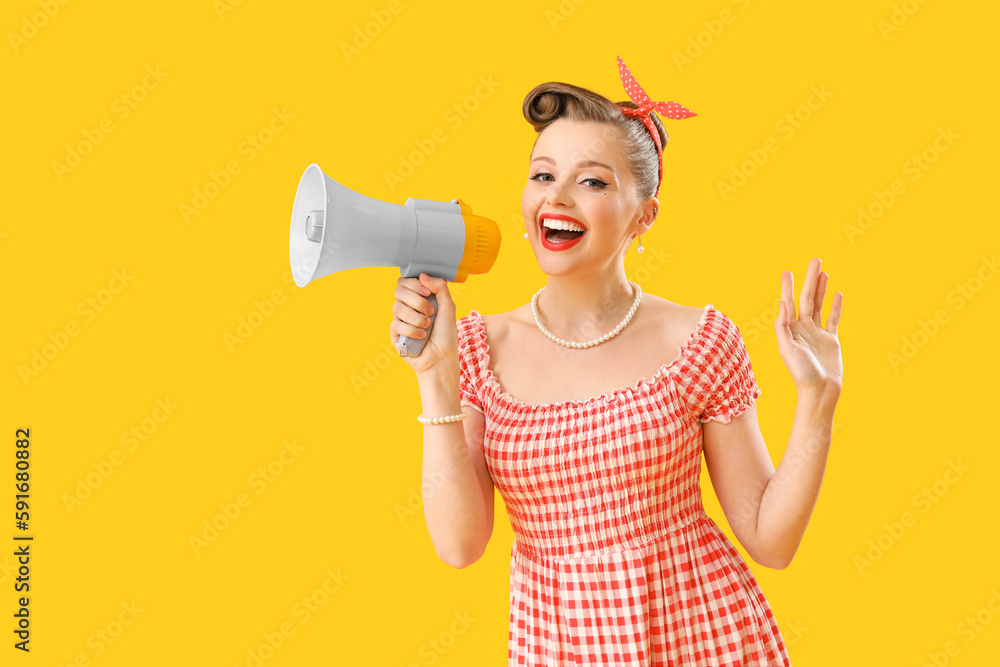 Young pin-up woman with megaphone on yellow background Young pin-up woman with megaphone on yellow background