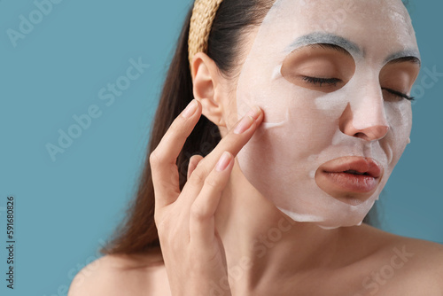 Young woman with sheet mask...