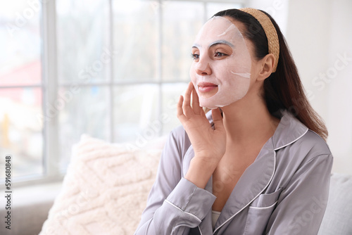 Young woman with sheet mask...