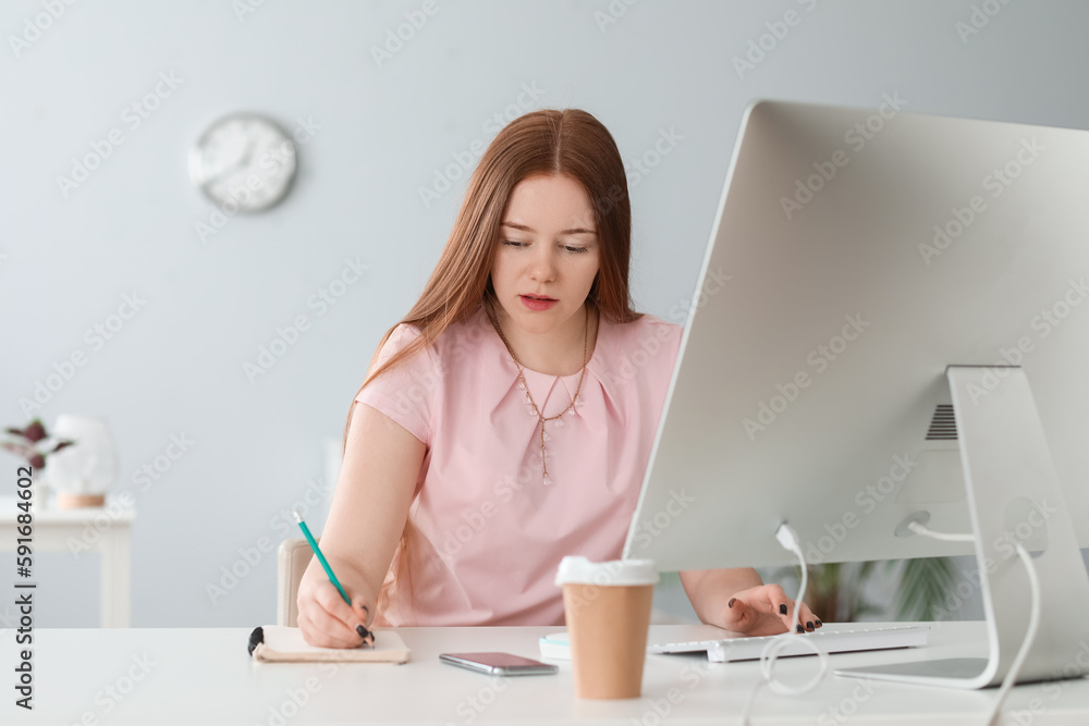 Female programmer working at table in office Female programmer working at table in office
