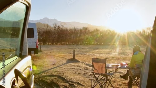 Tourist sit eat breakfast in sunny morning by camper van in official Icelandic campsite while travel on vacation with camper van. Skaftafell campground by glacier in national park