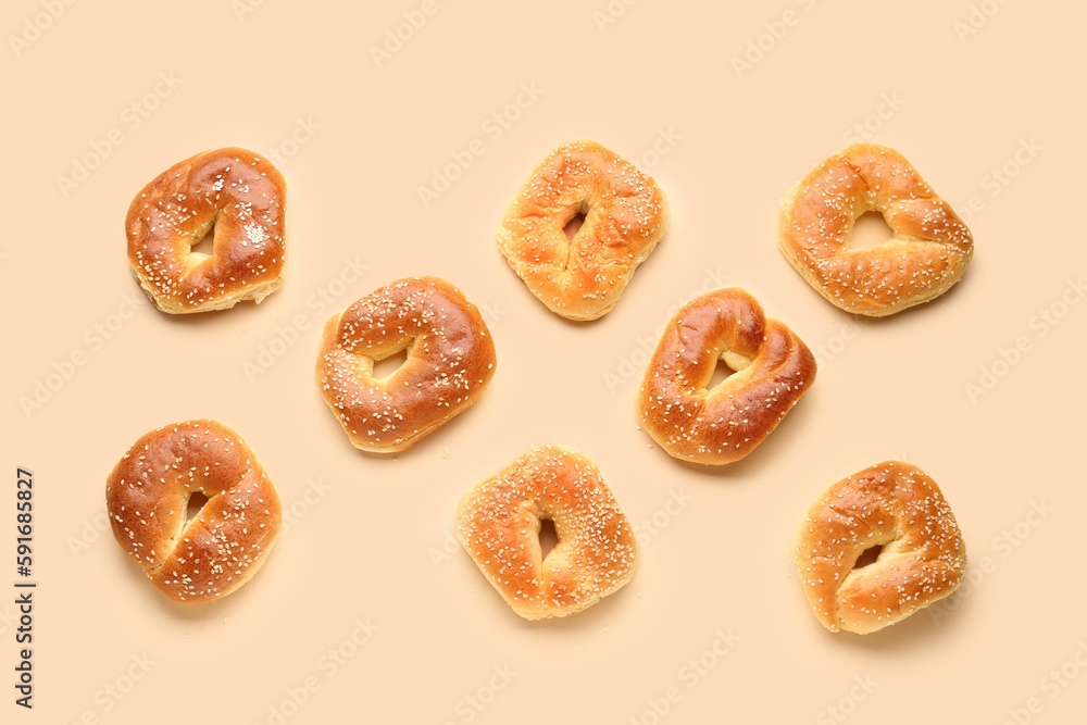 Tasty bagels with sesame seeds on beige background