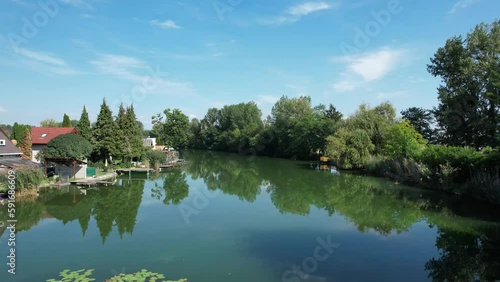 Aerial drone shot flying above a river with holiday homes on the side