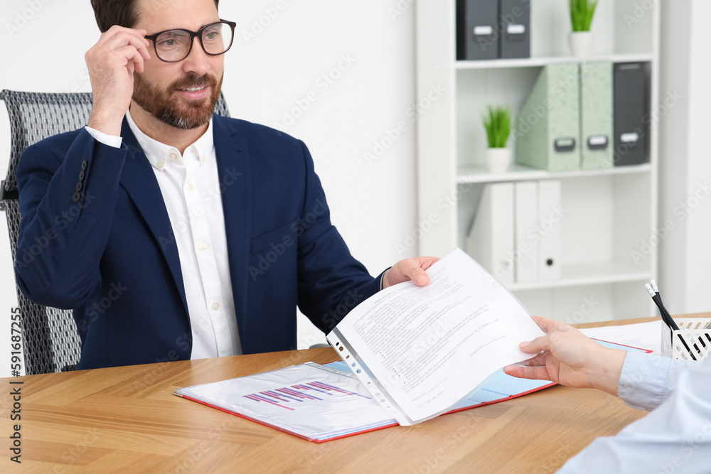 Businesspeople working with documents at table in office Businesspeople working with documents at table in office