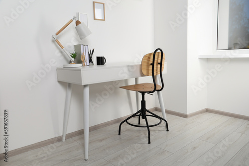 Comfortable workplace with white desk near wall at home © New Africa