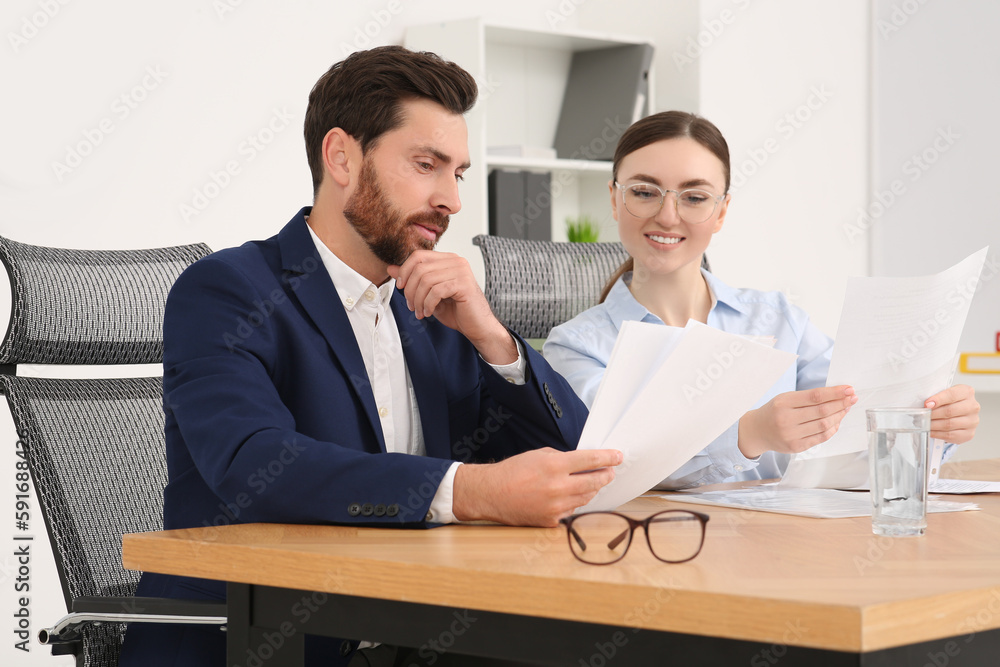 Businesspeople working together with documents in office Businesspeople working together with documents in office