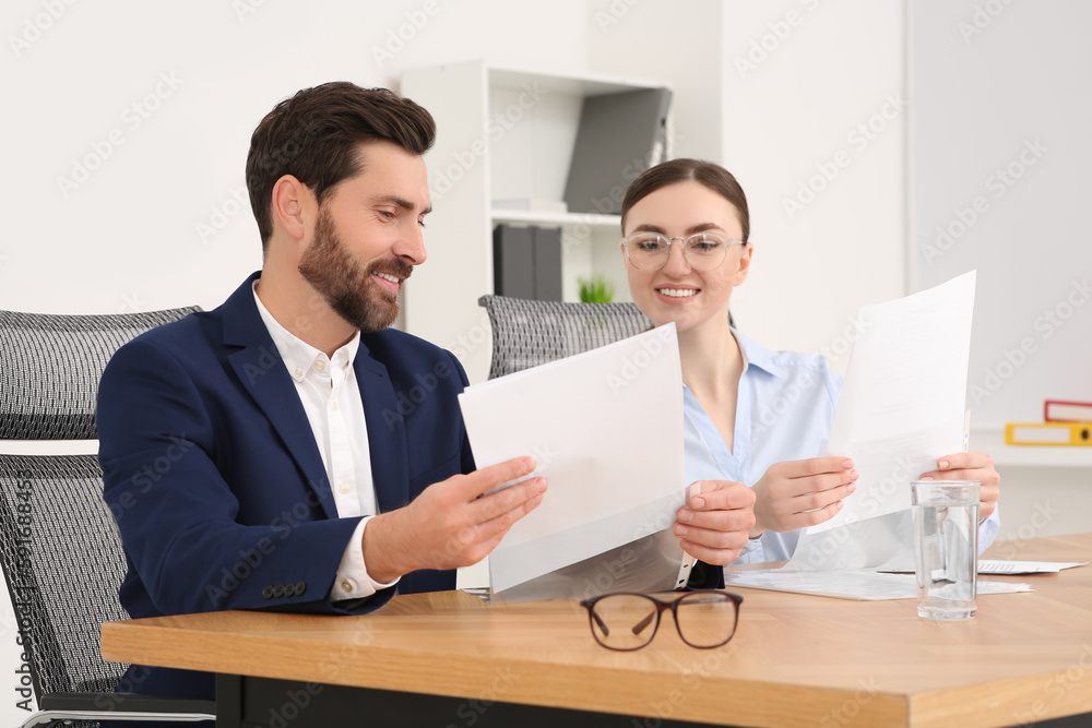Businesspeople working together with documents in office Businesspeople working together with documents in office