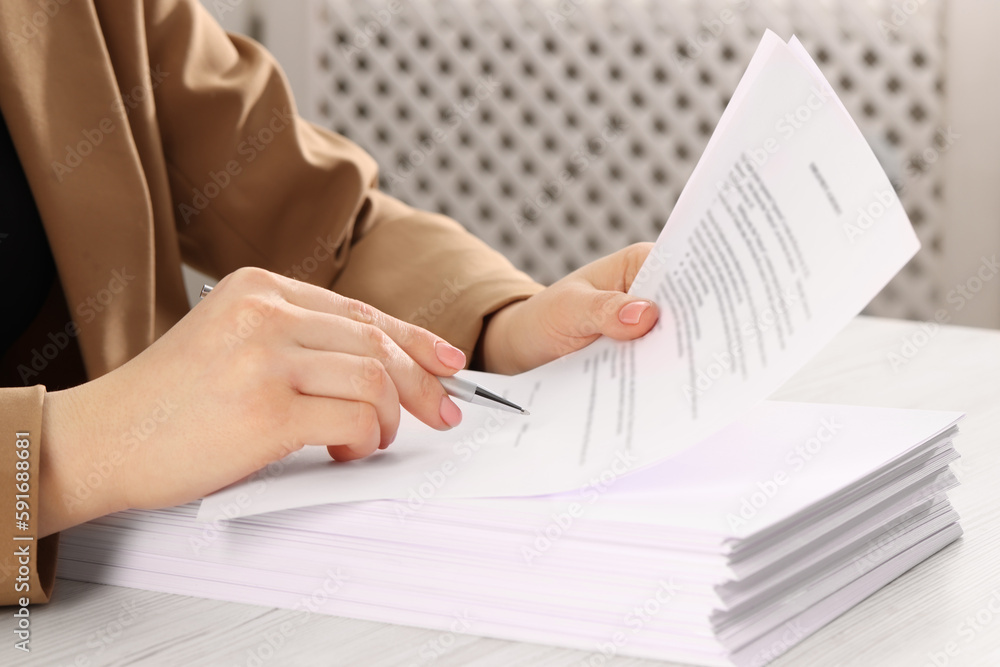 Woman signing document at wooden table, closeup Woman signing document at wooden table, closeup