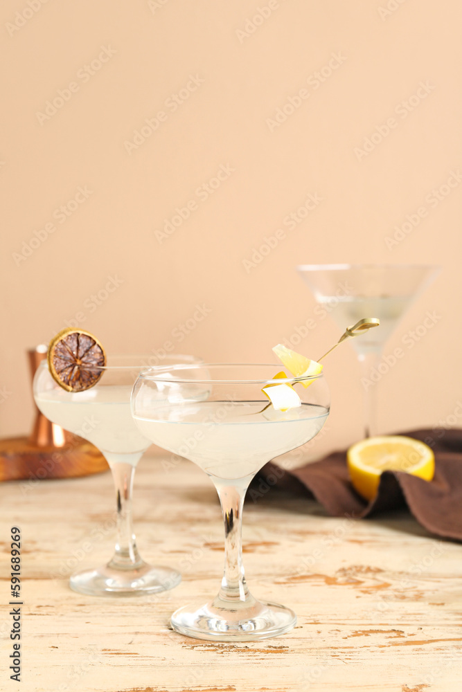 Glasses of martini with lemon on light wooden table Glasses of martini with lemon on light wooden table