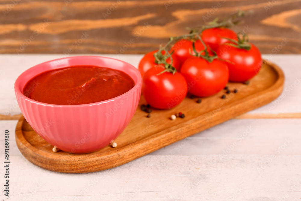 Bowl with tasty tomato paste on table